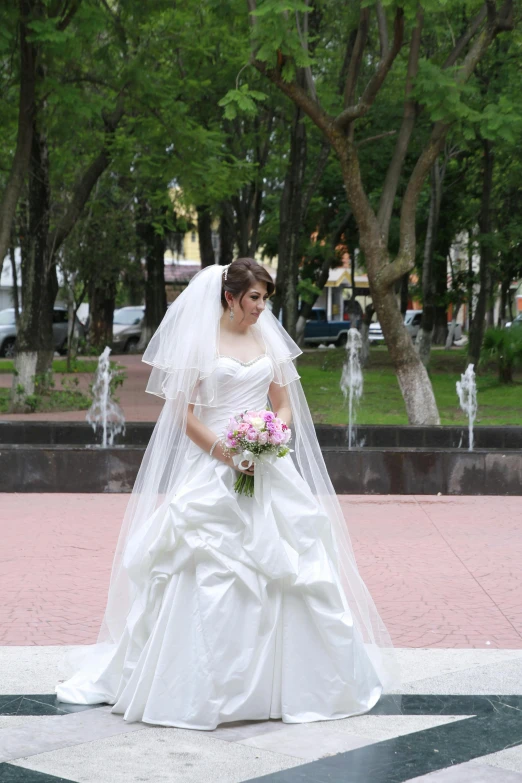 the bride is wearing a gown with one shoulder