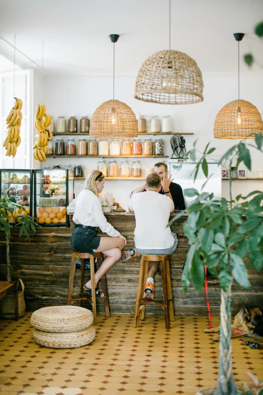 three people sitting at tables in a cafe