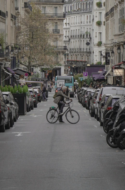 a person rides a bicycle through a large lot of cars