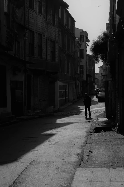 black and white image of a person walking down the street