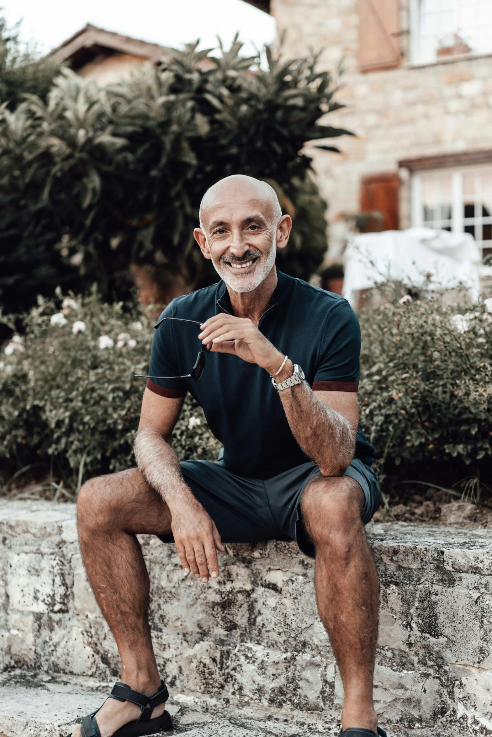 a man sits down smiling in his sandals