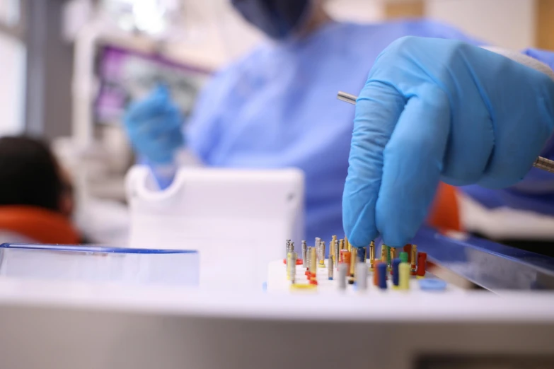 gloved hands working on several sys in a laboratory