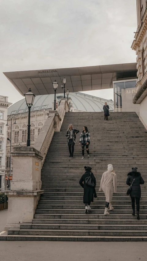 several people walking down some stairs in the middle of town