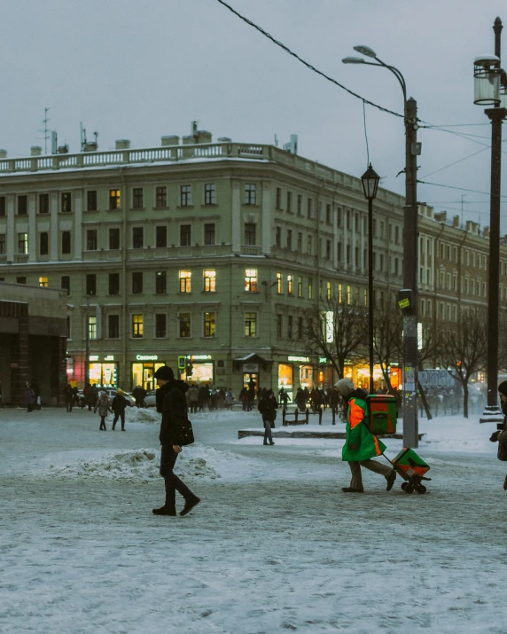 a group of people walk along the sidewalk in a city plaza