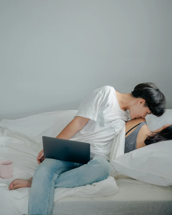 a woman and a man laying on a bed next to each other