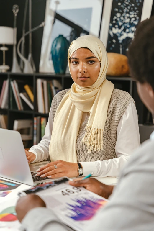 two women sitting at a table working on laptops