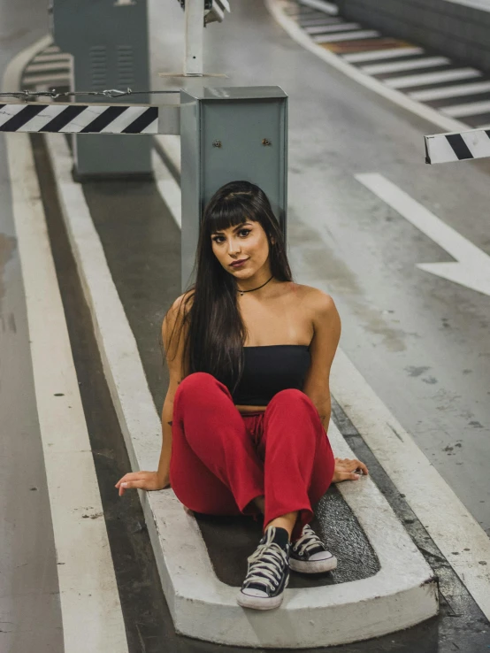 a woman sits on a cement ledge in the rain