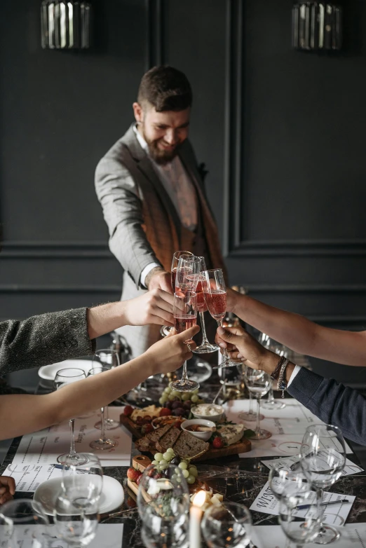 a group of people holding their glasses at a dinner table