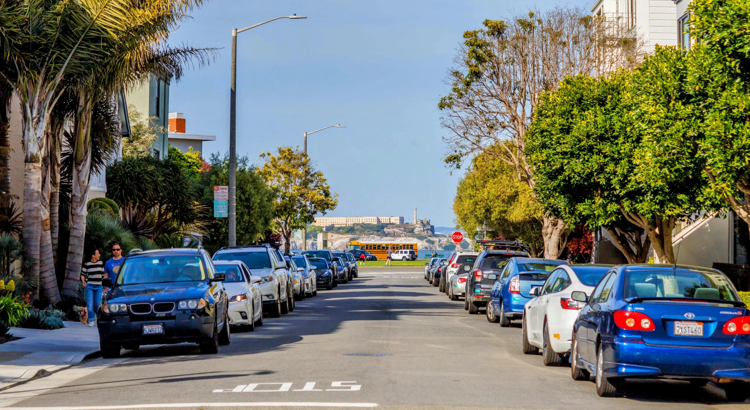 a row of parked cars on the side of a road