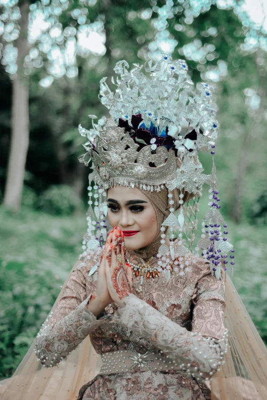 a woman in elaborate dress and veil poses for the camera