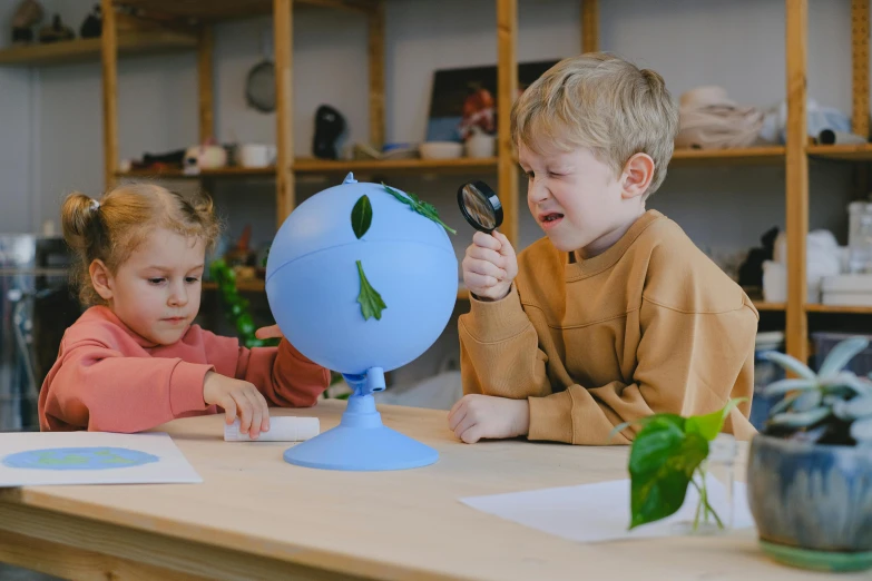 children working with a plant on a desk