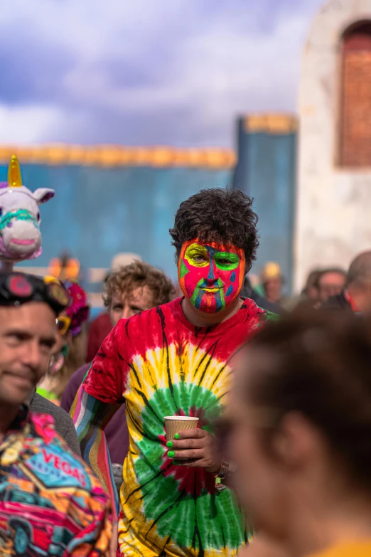 people at a festival with their faces painted like unicorns