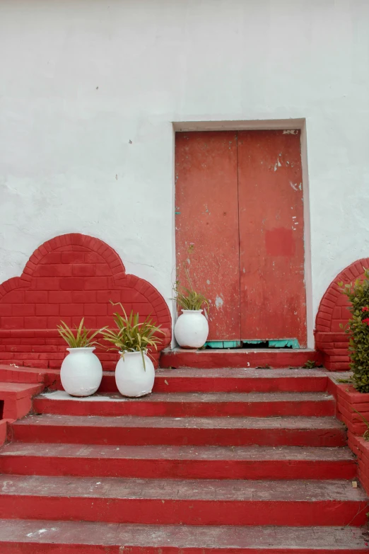 red steps leading to white painted pots on red step