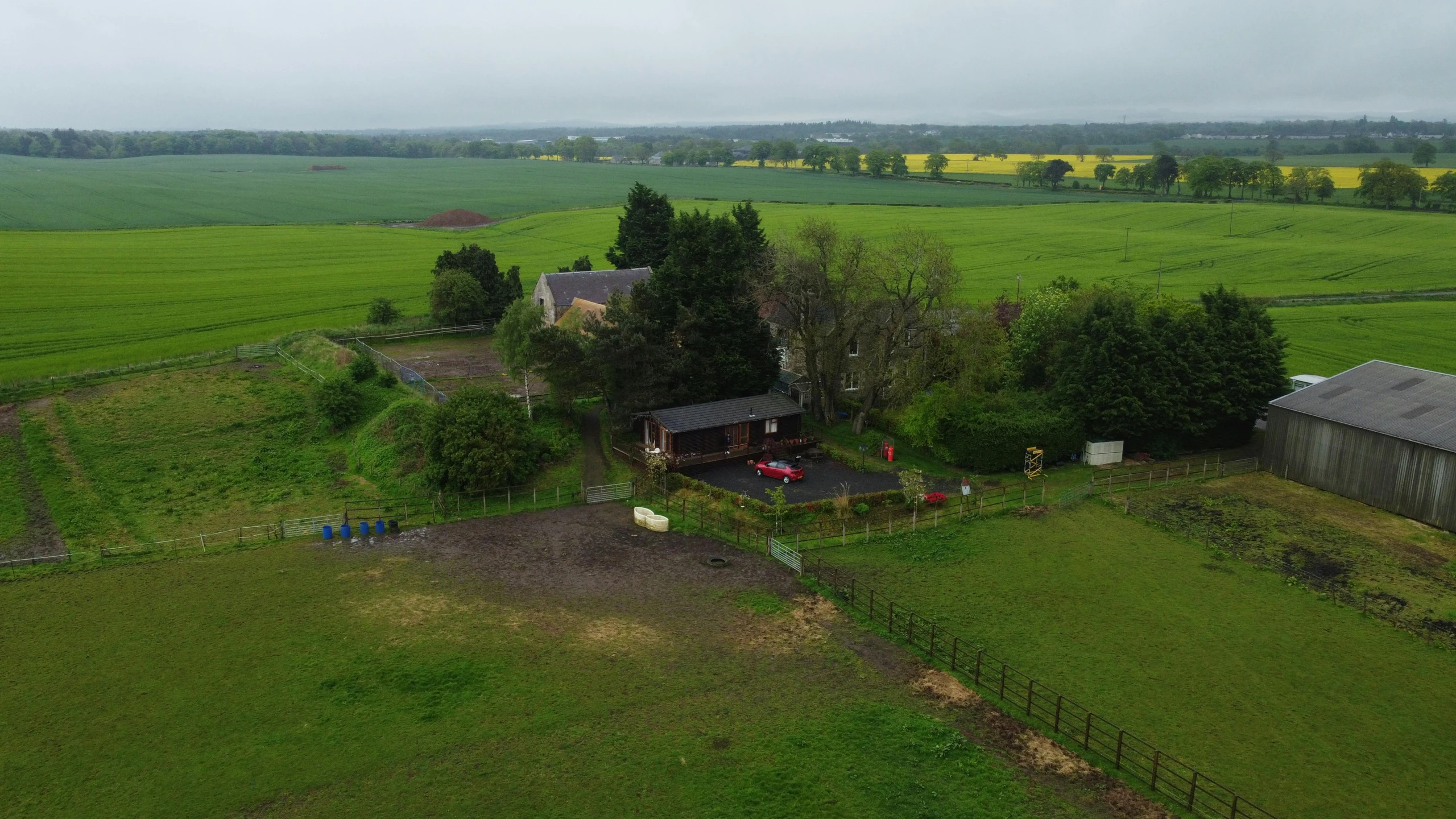 the farm includes several large farm buildings and a house on one side and two smaller ranches on the other