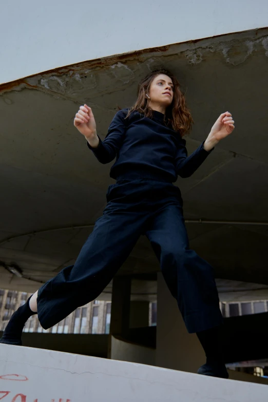 a woman in mid - leap while standing on a wall