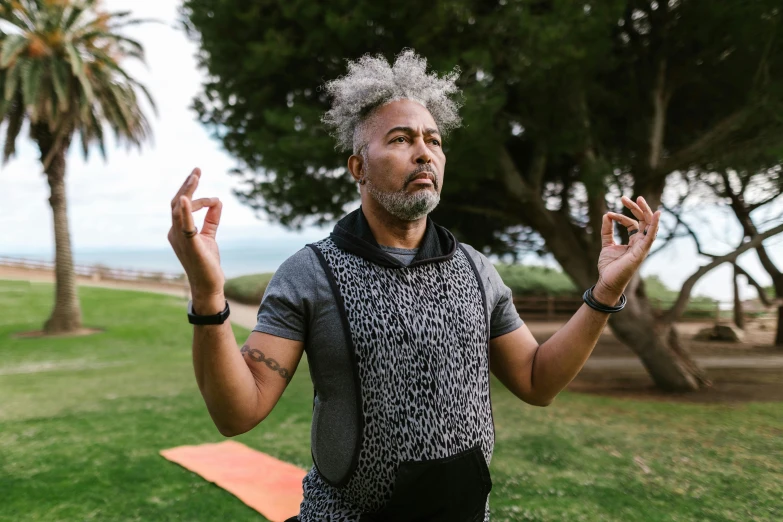 the man is standing in the park holding up his hands