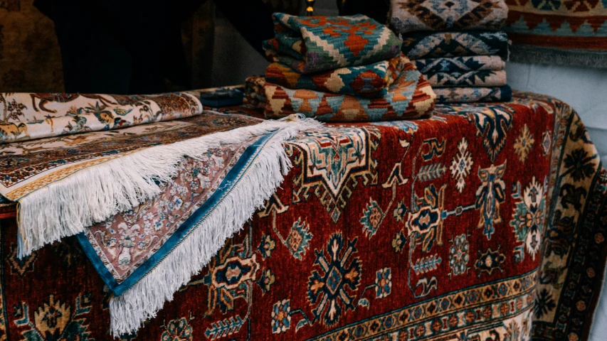 several large rugs are displayed on the bed