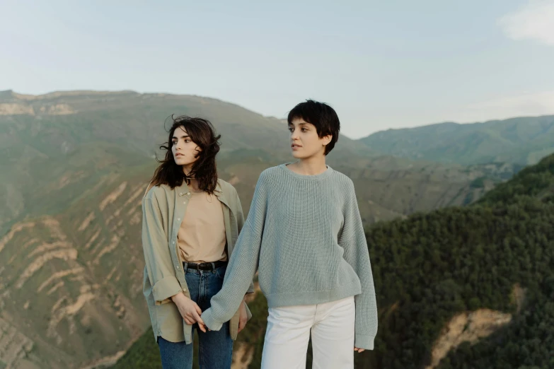 two girls with hands on hips standing in front of the mountains