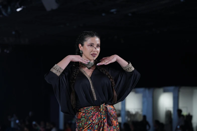 a woman making gestures at a fashion show