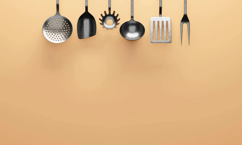 a yellow wall that has several different types of cooking utensils