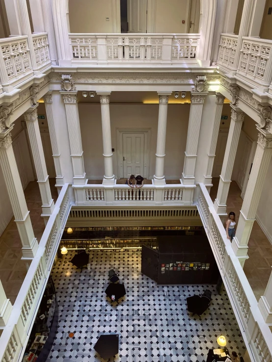 an inside view of a building with people and tables