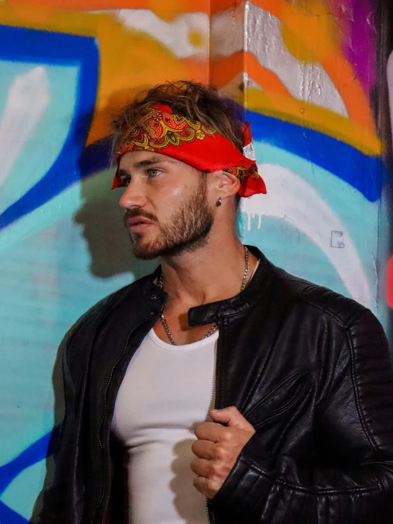 a man wearing a bandana poses for a pograph