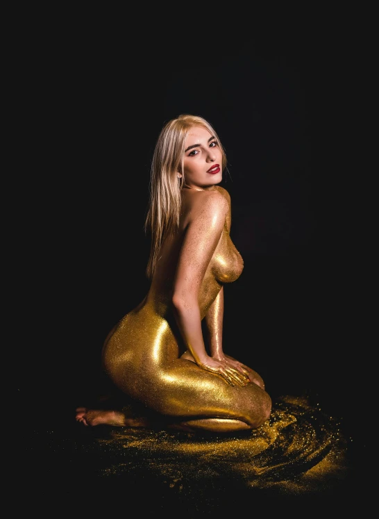 a  blonde sitting on top of a gold colored substance