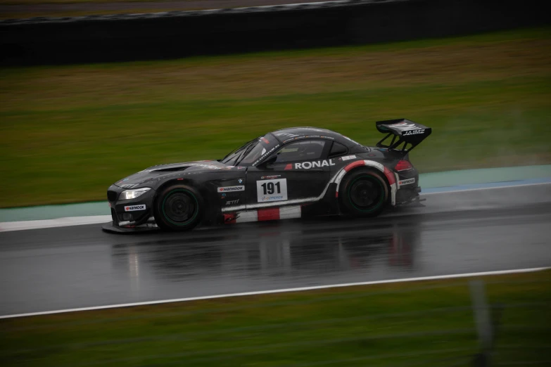 a silver sports car driving down a track