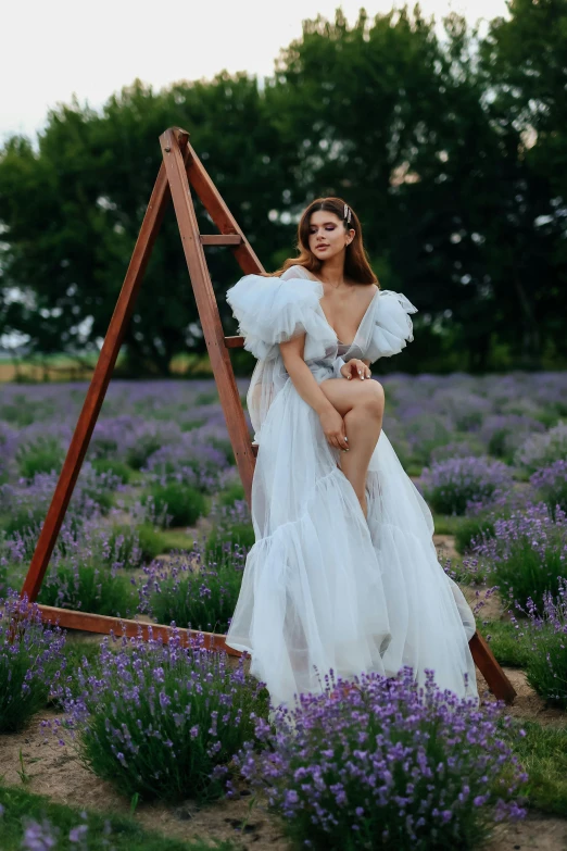 a girl is wearing a white dress sitting on a swing