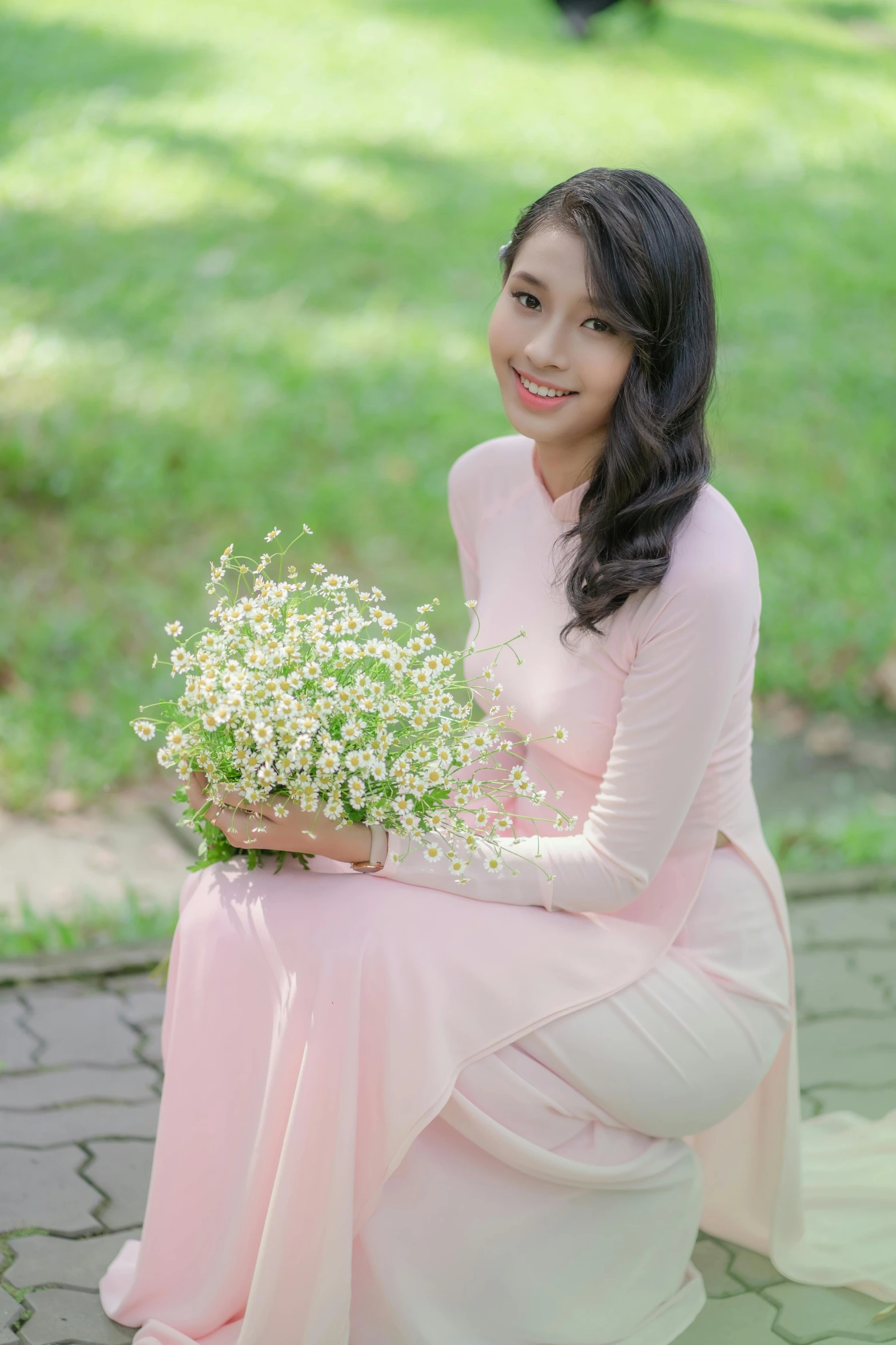 a woman sitting on the ground holding a flower