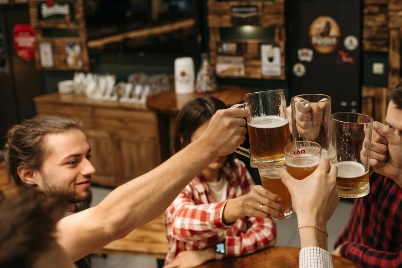 a group of friends at a bar raising their glasses