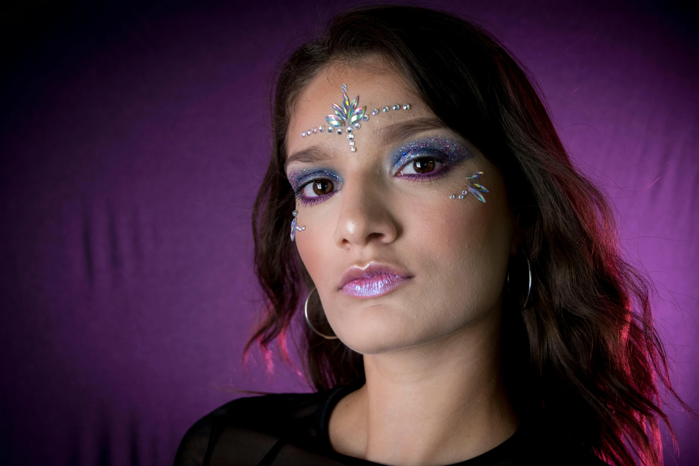 a young woman with eye makeup and a blue and pink design