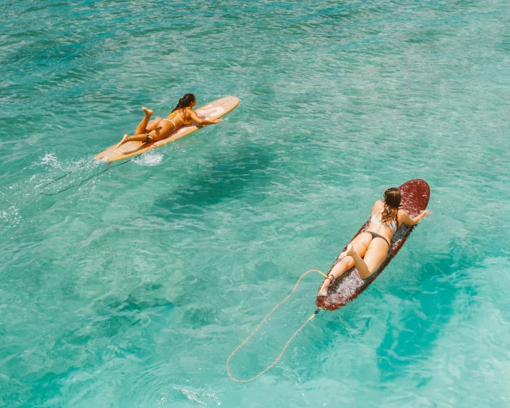 two people are floating in the ocean, on their boards