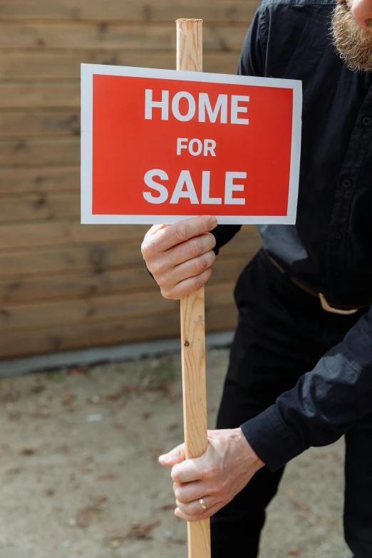 a man with a sign holding a stick