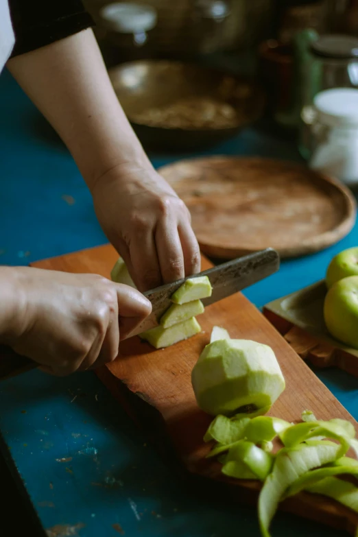 a woman is chopping apples on a  board