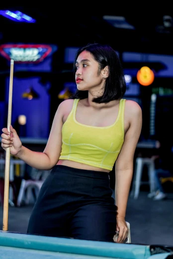 a beautiful young lady holding a pool stick