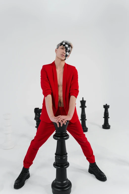 a man with hair and makeup sitting on a post