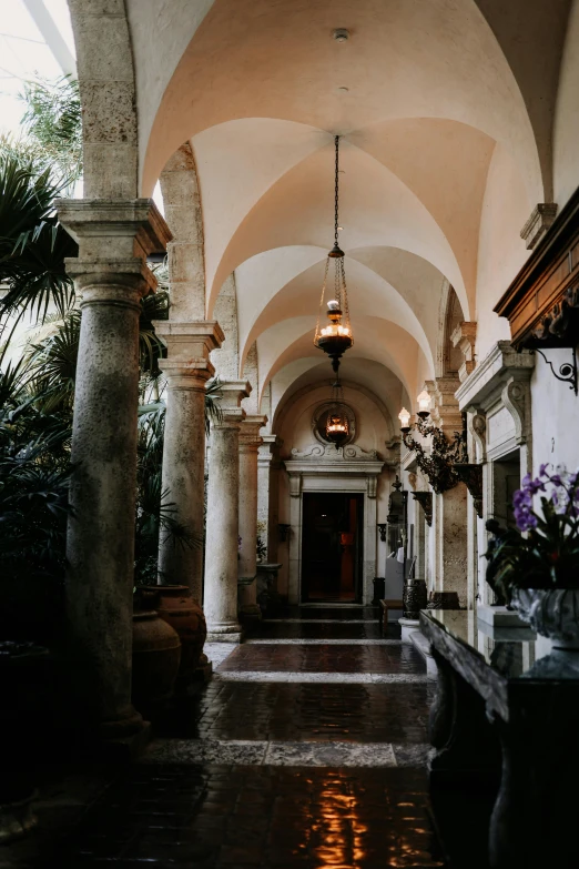 a hallway with arches and hanging lamps