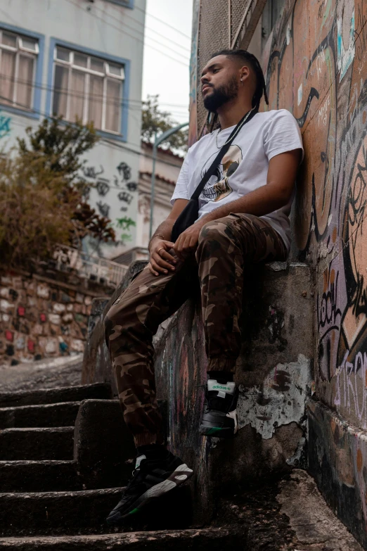 a man sitting on top of cement steps next to a wall