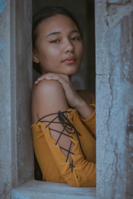 a woman with a tied - up sweater and a chain around her neck