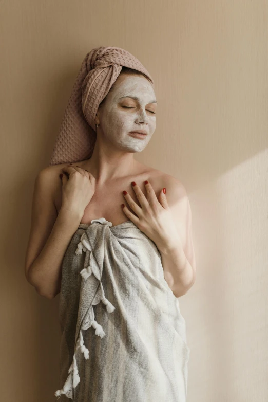 a woman in a towel with a face mask on