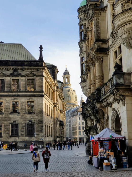 pedestrians strolling by old city buildings in an older city