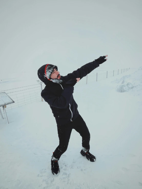 the man is throwing a frisbee in the snow