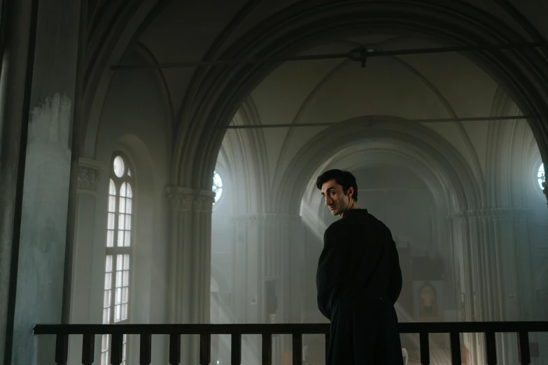 a man standing by the railing with the windows