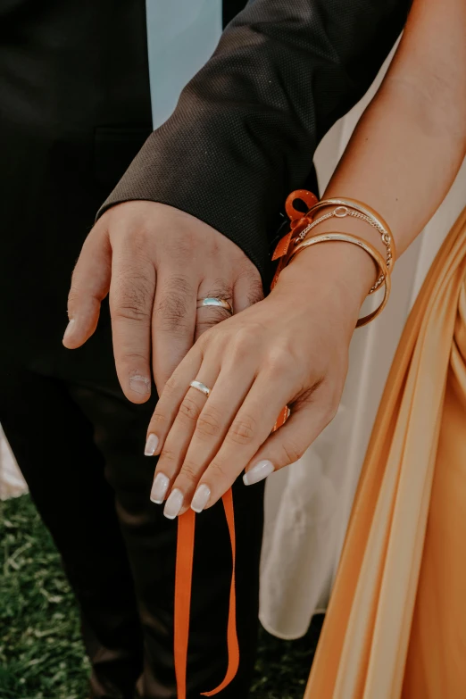 a woman holding her husband's hand while holding onto an orange band