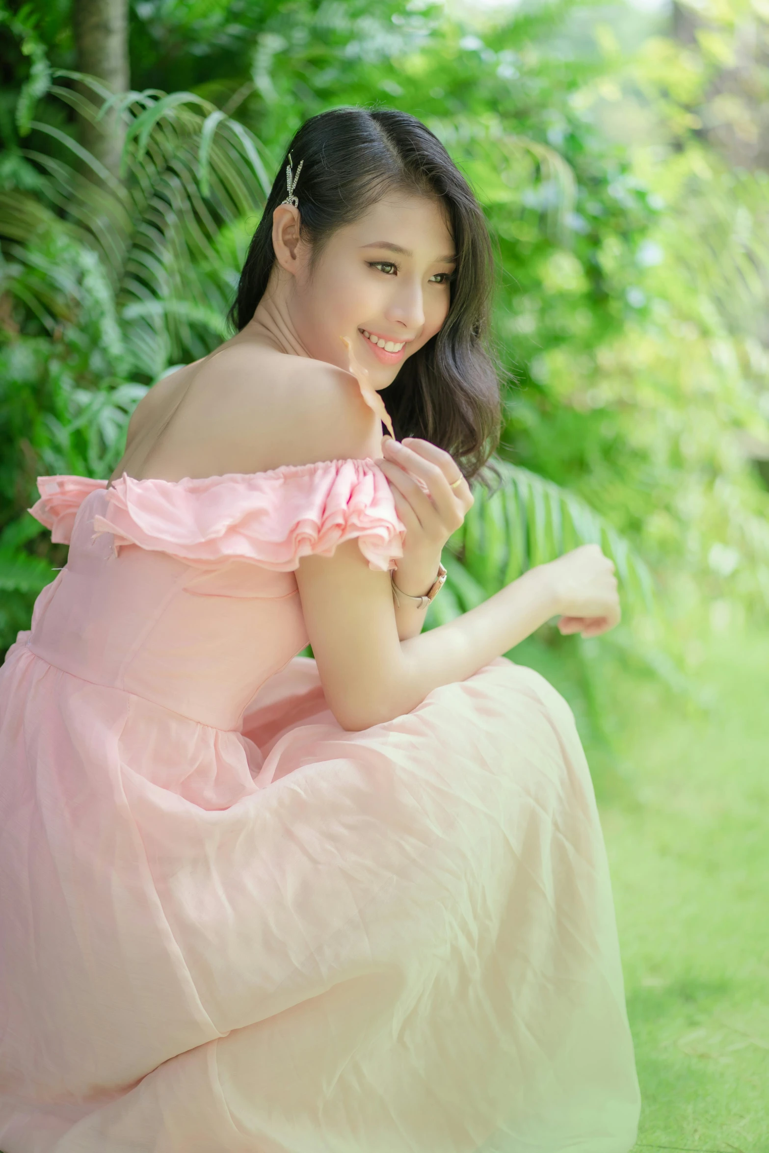 a woman in a pink dress sitting outside