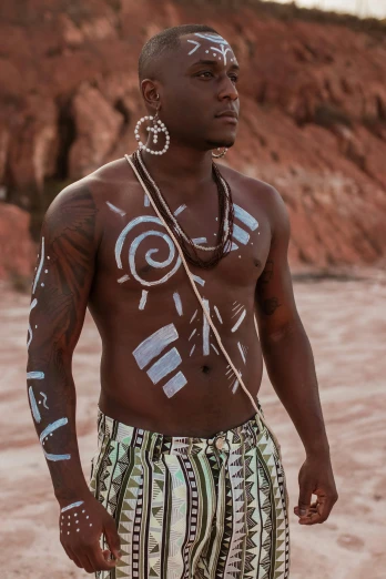 a man with body paint has various items on his body
