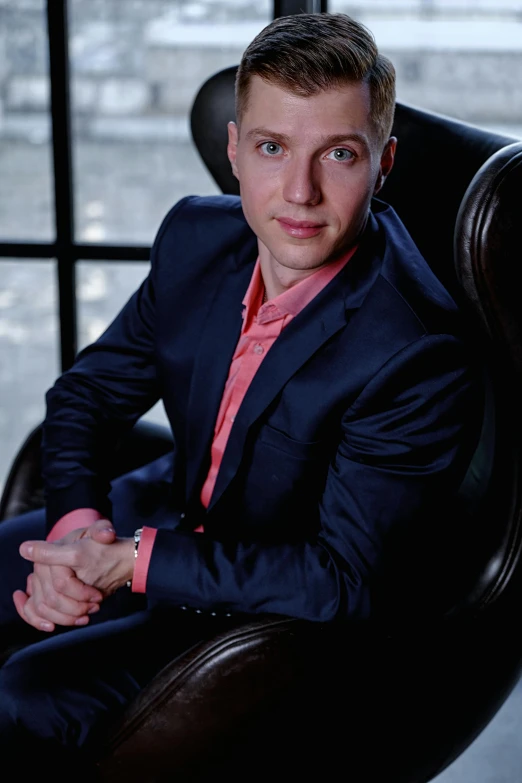 man sitting in leather chair in front of window