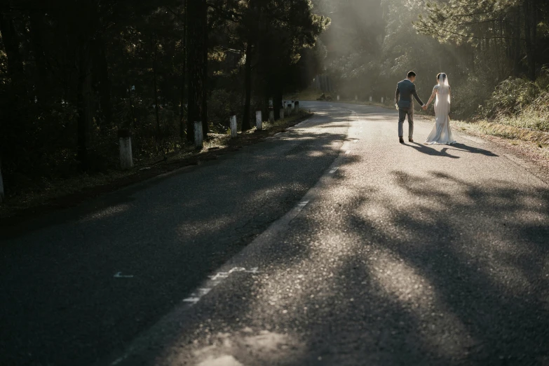 a couple holding hands walking down a quiet road