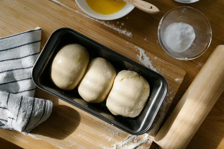 some white dough rolls in a pan on a table